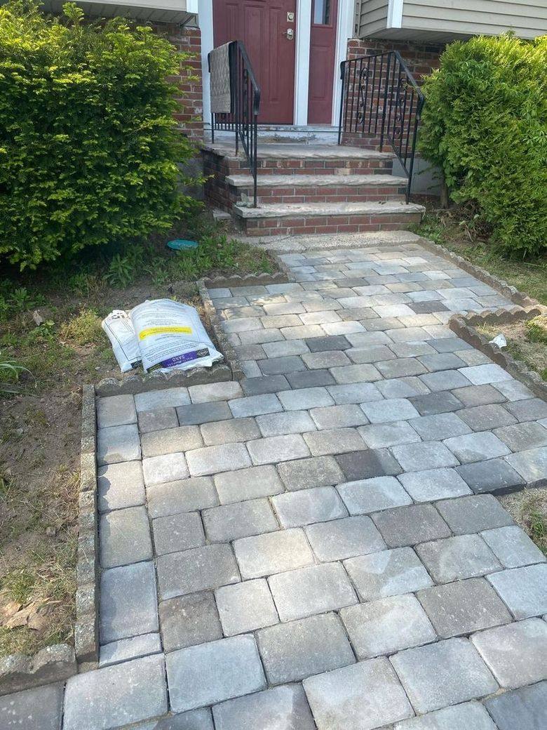 Finished tumbled paver walkway running up to the brick front steps