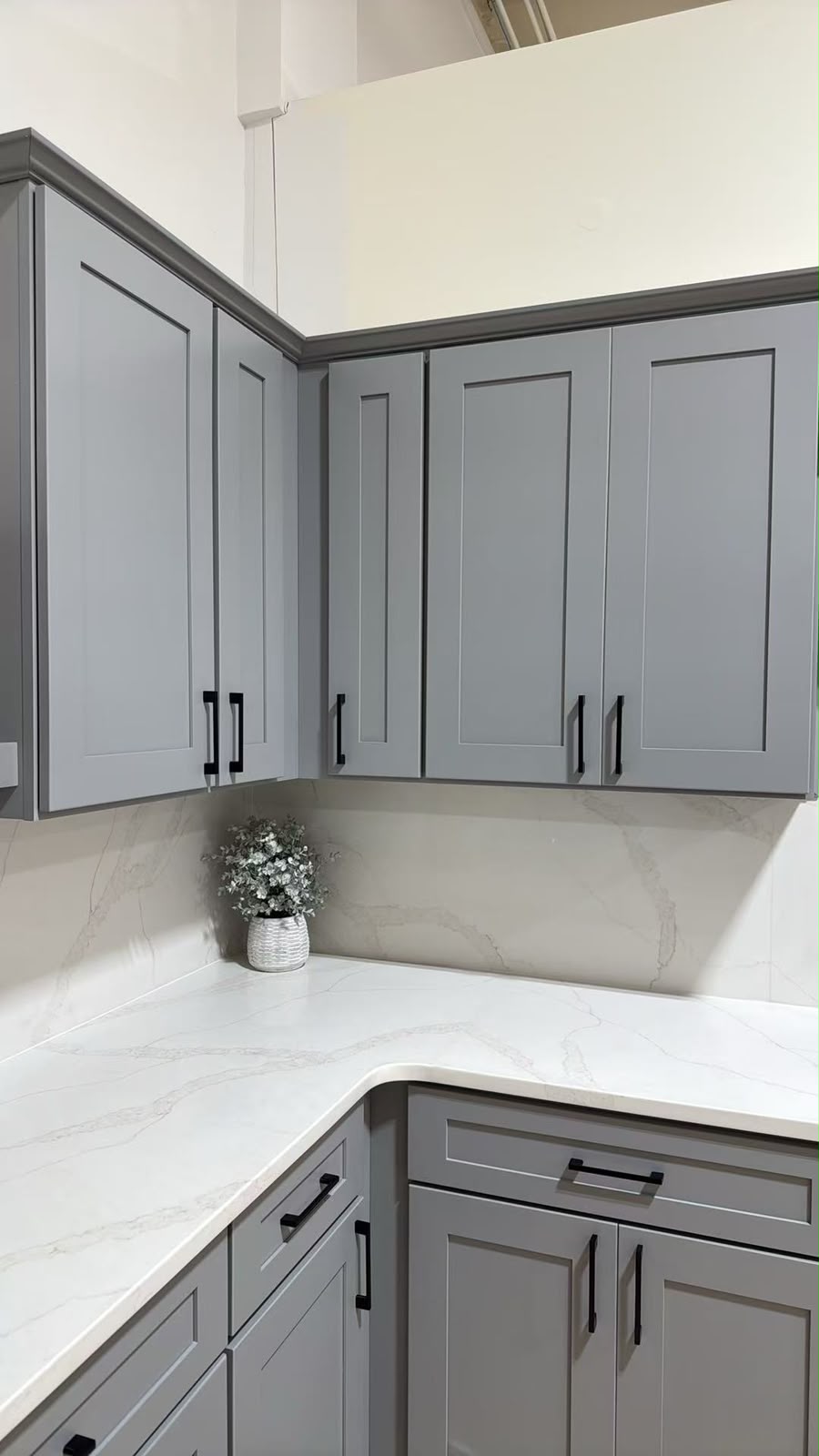 Corner detail of the light grey Shaker display showing the crown moulding and quartz counter