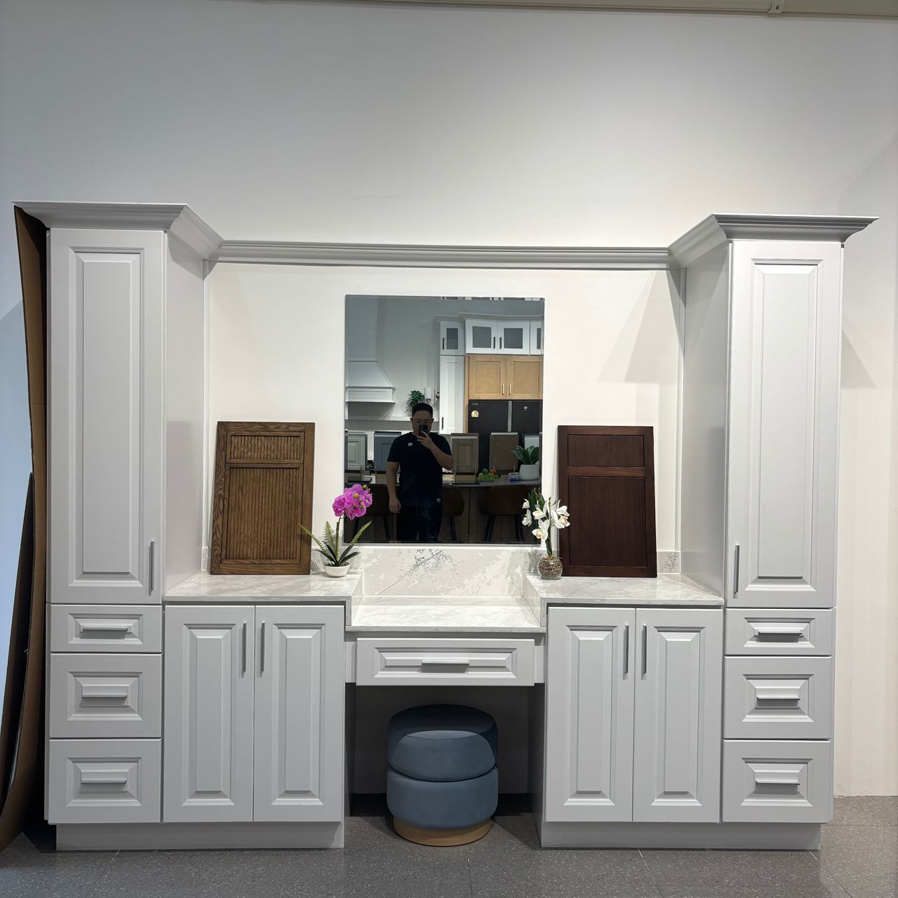 White raised panel vanity with a make up station, mirror and two tall linen towers