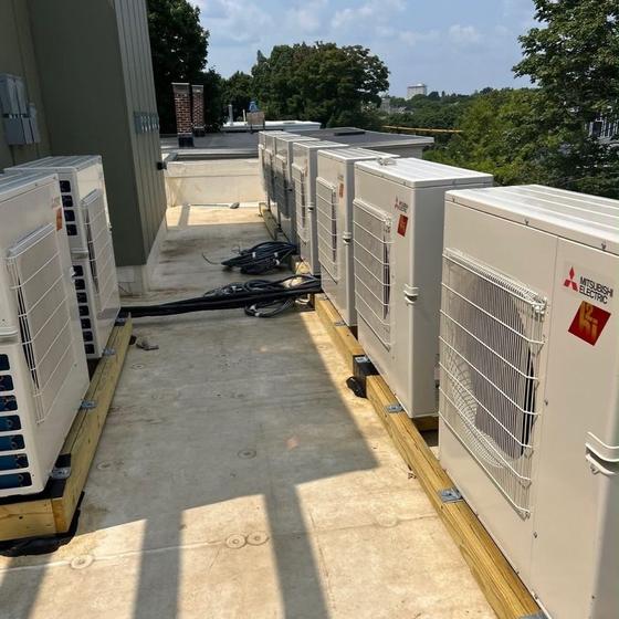 Row of rooftop HVAC condensing units on a commercial building