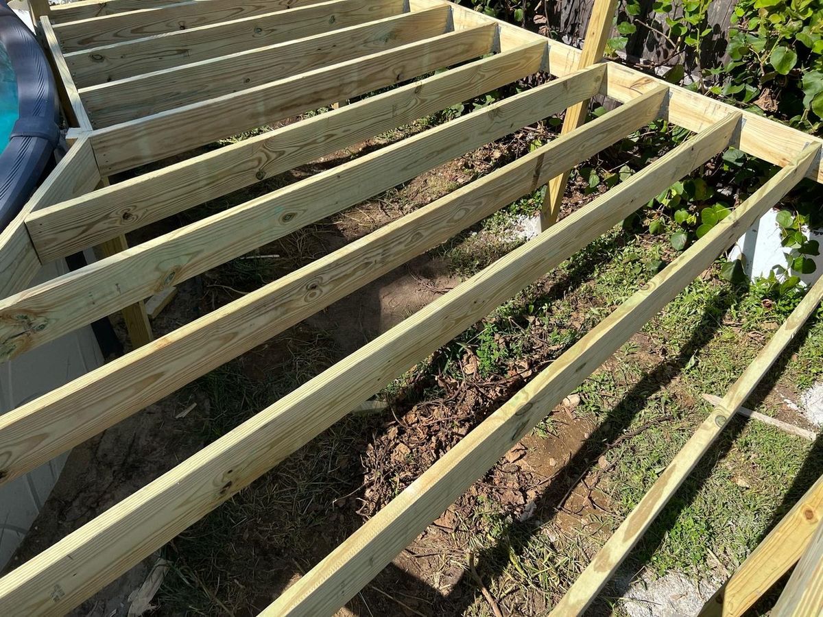 Our own crew framing a deck, joists and hangers going in